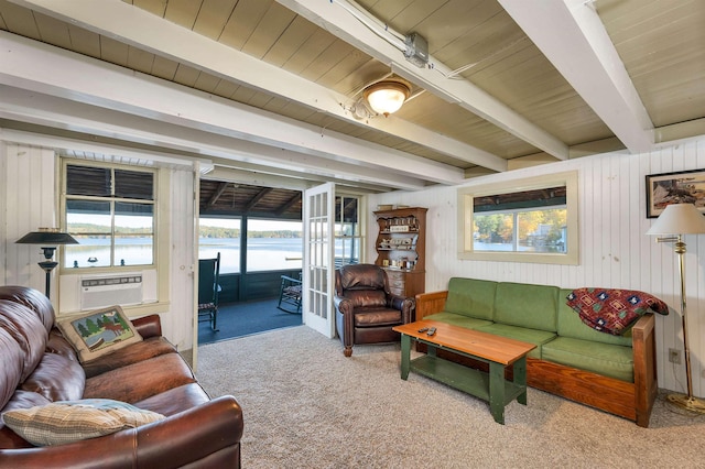 living area featuring carpet floors, beamed ceiling, wooden ceiling, and a wealth of natural light