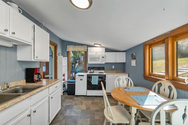 kitchen featuring stone finish floor, plenty of natural light, electric stove, and white microwave