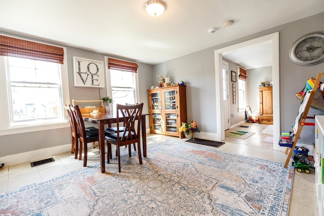 tiled dining room with baseboards and visible vents