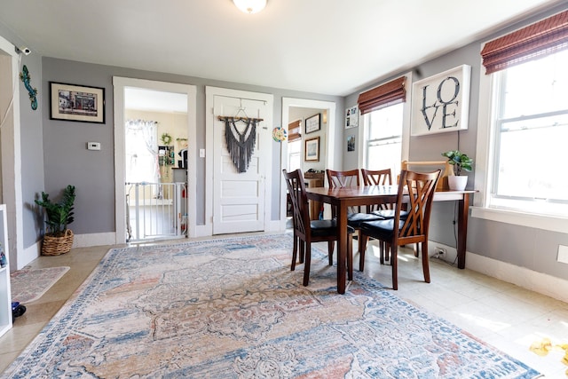 dining room with baseboards and tile patterned flooring