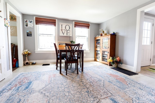 dining space featuring baseboards, a wealth of natural light, tile patterned flooring, and visible vents