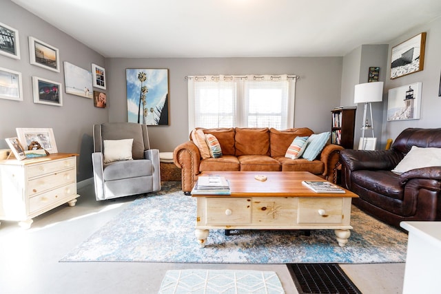 living room featuring concrete flooring and baseboards
