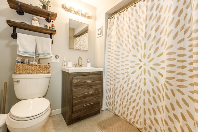 bathroom with baseboards, vanity, and toilet