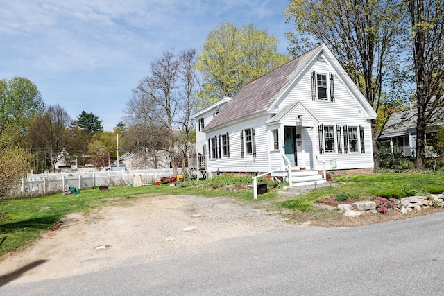 view of front of property featuring fence, a shingled roof, and a front yard