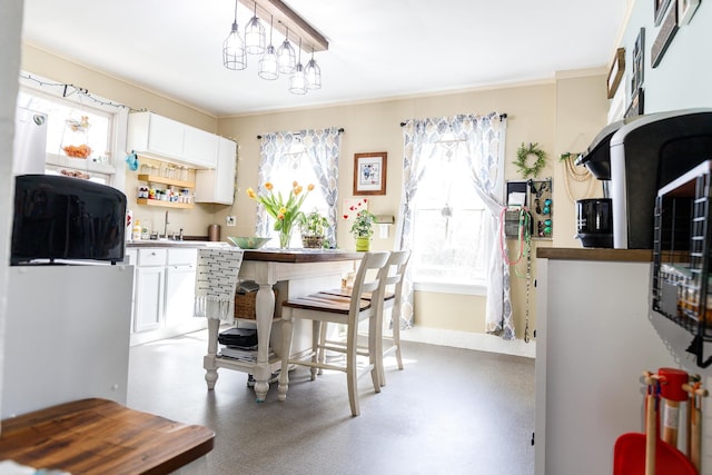 kitchen featuring ornamental molding, a sink, and white cabinets