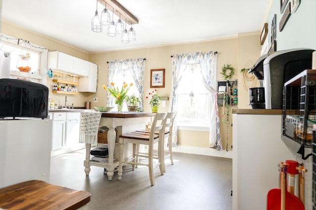 kitchen featuring ornamental molding, white cabinetry, and a healthy amount of sunlight