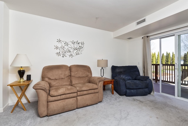 living area featuring baseboards, visible vents, and carpet