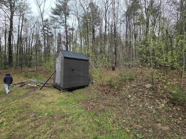 view of shed featuring a view of trees