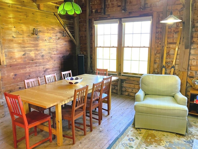 dining space featuring wood walls and hardwood / wood-style floors