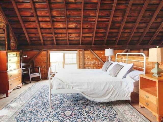 bedroom featuring wooden walls, lofted ceiling with beams, and wood ceiling