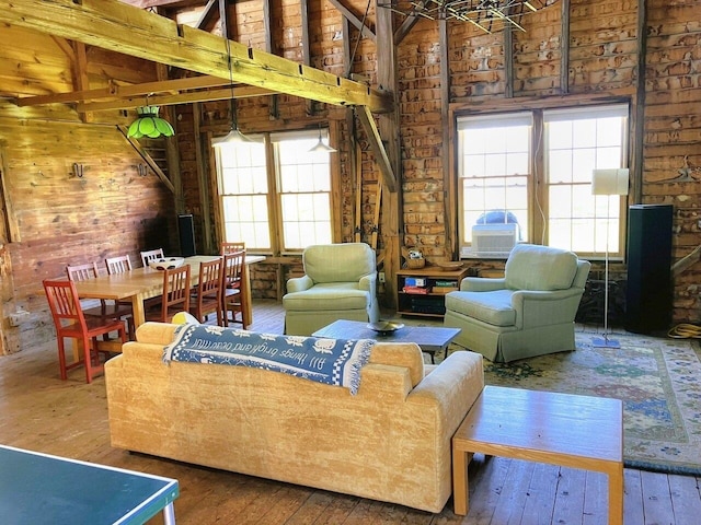 sitting room with lofted ceiling, a wealth of natural light, and hardwood / wood-style flooring