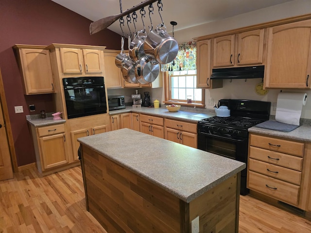 kitchen with light brown cabinetry, black appliances, light wood-type flooring, and under cabinet range hood