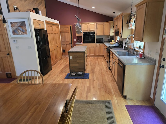 kitchen with a kitchen island, vaulted ceiling, light wood finished floors, and black appliances