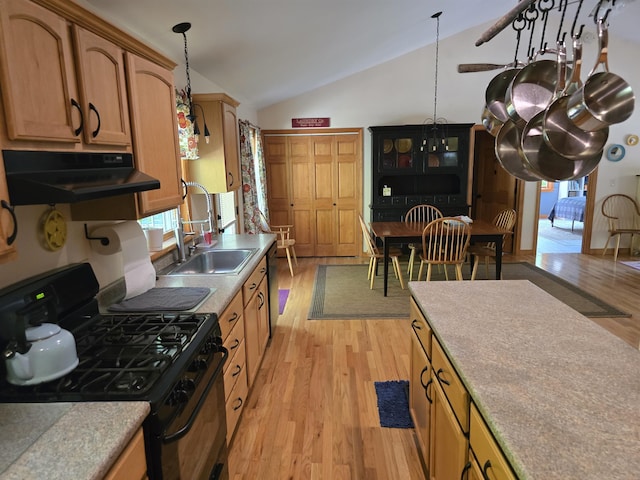 kitchen with black gas range, under cabinet range hood, a sink, light wood-style flooring, and vaulted ceiling