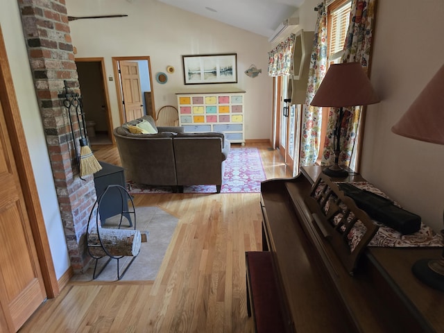 living room with light wood-type flooring and vaulted ceiling