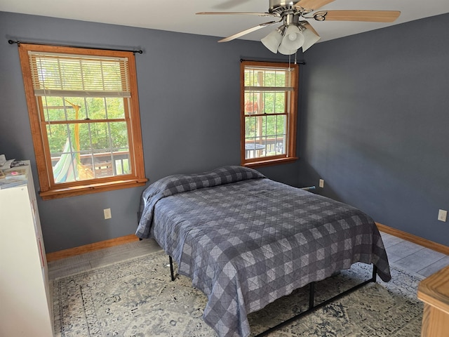 bedroom with baseboards, ceiling fan, and wood finished floors