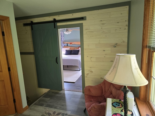 interior space featuring wood walls, a barn door, and wood finished floors