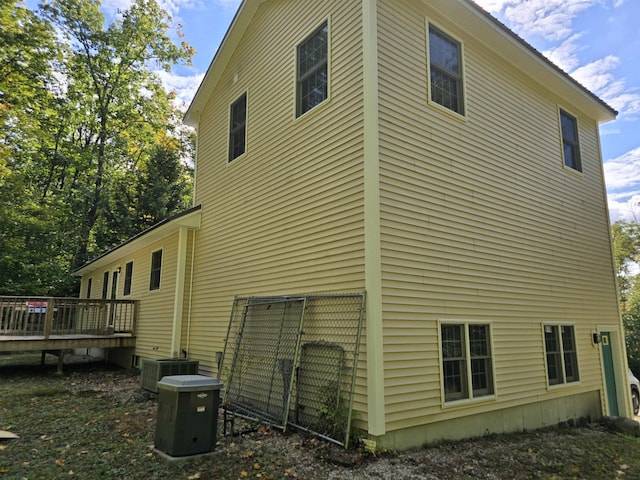 view of home's exterior with a wooden deck and central AC unit