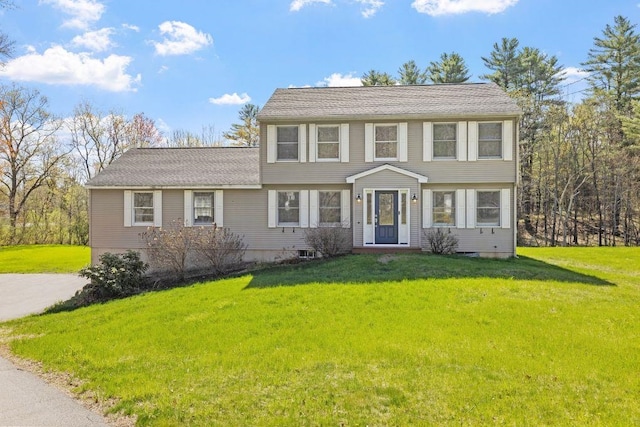 colonial inspired home featuring a front lawn