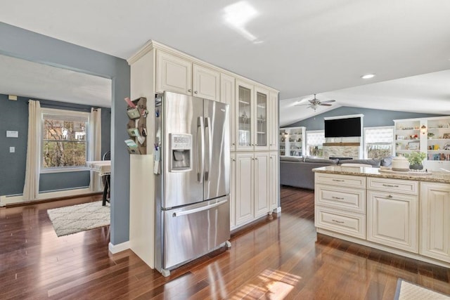kitchen with a healthy amount of sunlight, cream cabinets, stainless steel refrigerator with ice dispenser, and lofted ceiling