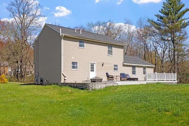 back of house featuring a lawn and a deck
