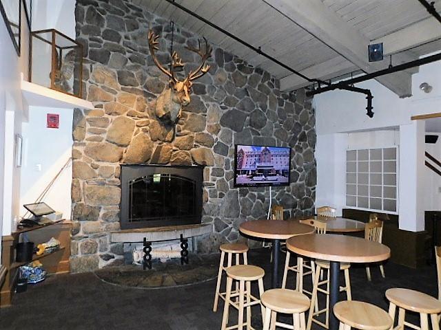 dining area featuring wooden ceiling, a fireplace, and beam ceiling