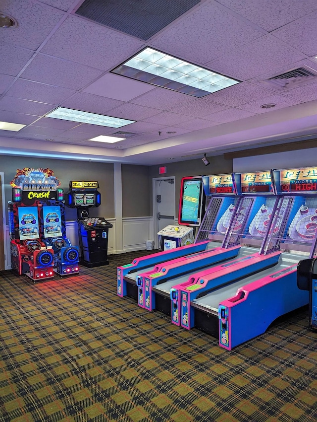 rec room with visible vents, wainscoting, carpet floors, and a paneled ceiling