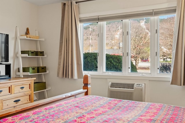 bedroom featuring a wall mounted AC and multiple windows
