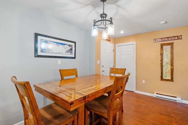 dining room with baseboards, a baseboard heating unit, a chandelier, and wood finished floors