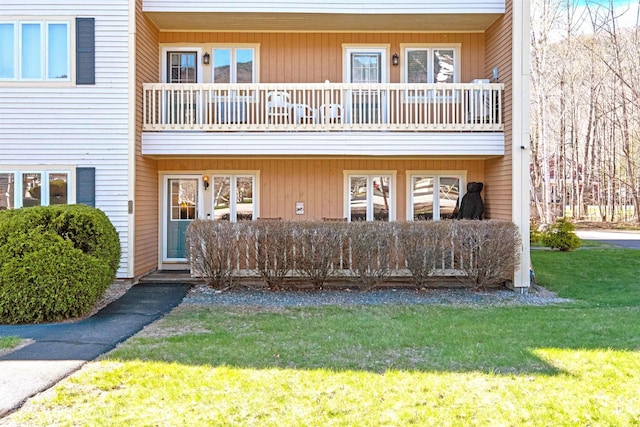 exterior space with a lawn and a balcony