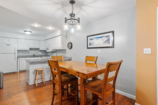 dining area with baseboards and wood finished floors