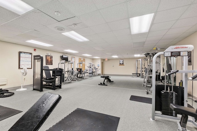 gym featuring baseboards and a paneled ceiling