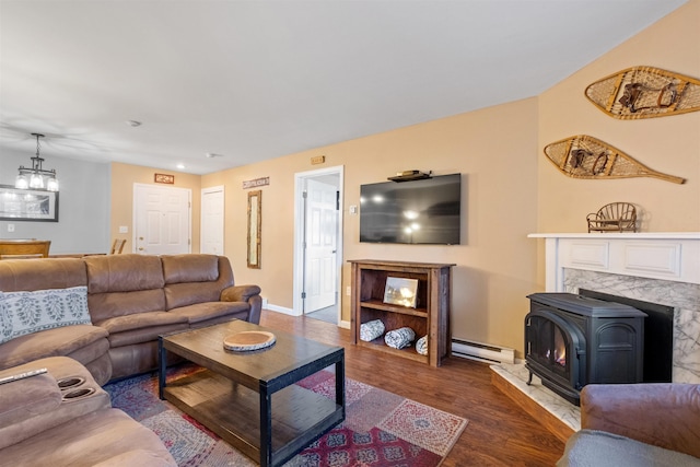 living room with baseboards, a notable chandelier, baseboard heating, and wood finished floors
