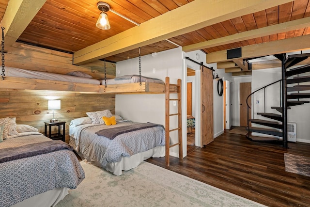 bedroom featuring beamed ceiling, a barn door, wood ceiling, and wood finished floors