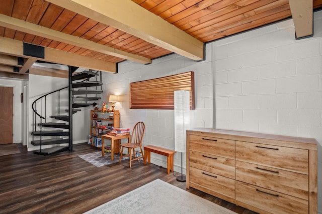 below grade area with concrete block wall, wooden ceiling, stairs, and dark wood-style floors