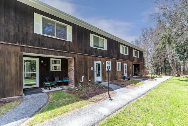 townhome / multi-family property featuring a porch and a front yard