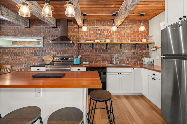 kitchen with wall chimney range hood, open shelves, wooden counters, stainless steel appliances, and wood ceiling