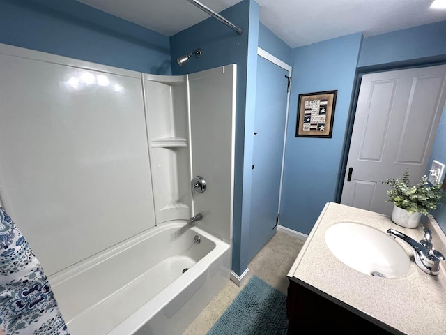 bathroom featuring vanity, baseboards, and bathing tub / shower combination