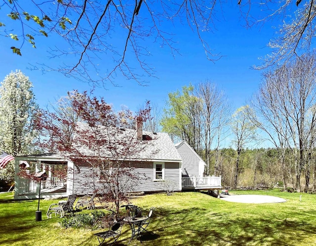 view of home's exterior with a lawn, a deck, and a chimney