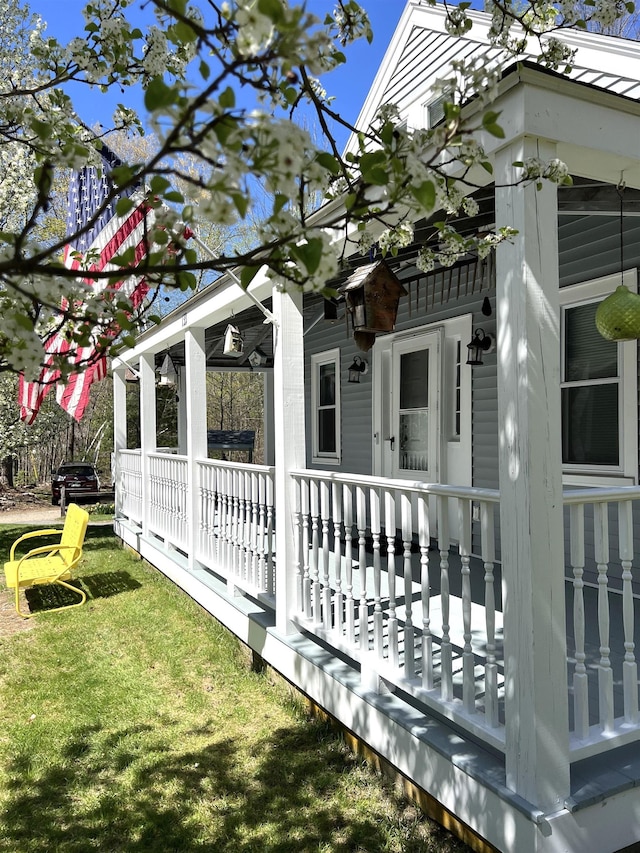 view of side of property featuring a yard and covered porch