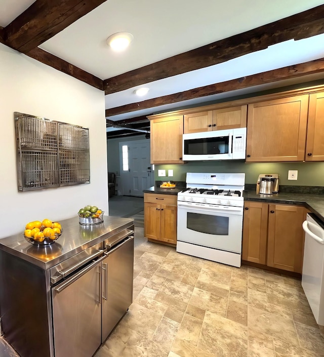 kitchen with dark countertops, stone finish flooring, beam ceiling, and white appliances