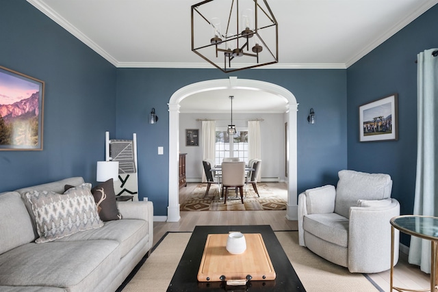 living area with crown molding, arched walkways, and ornate columns