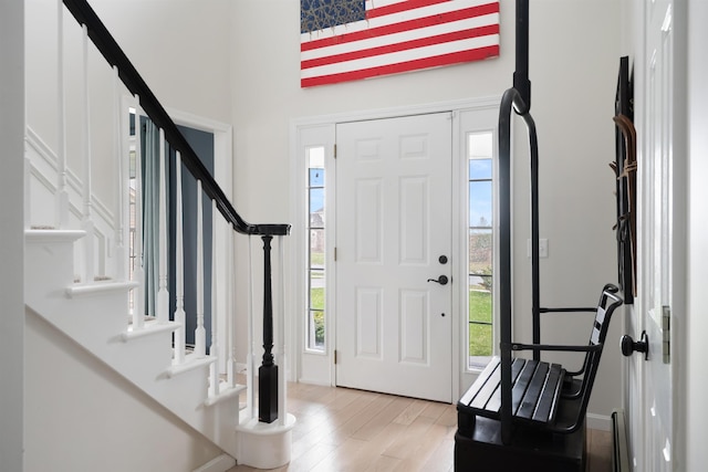 entrance foyer with stairs, plenty of natural light, and light wood-type flooring