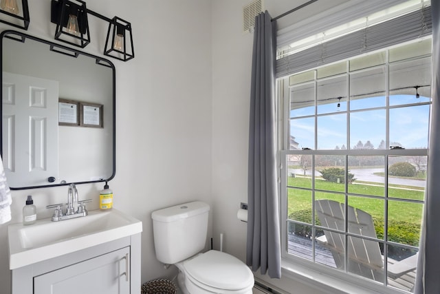 half bath featuring vanity, toilet, and visible vents