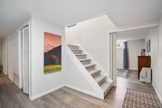 stairway featuring baseboards and wood finished floors