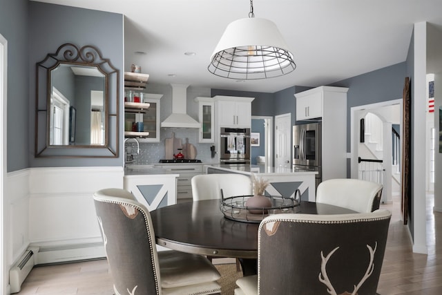 dining space featuring light wood-style floors and a baseboard radiator