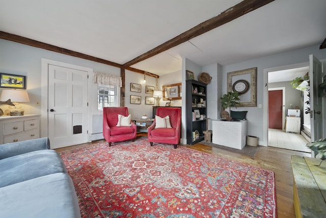 living area with beamed ceiling, wood finished floors, and a baseboard radiator