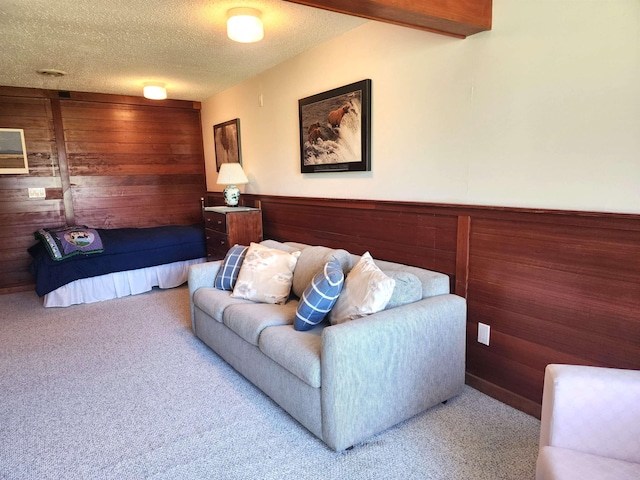 carpeted living area with wooden walls and a textured ceiling