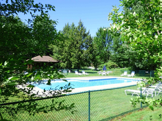 pool with a patio area and fence