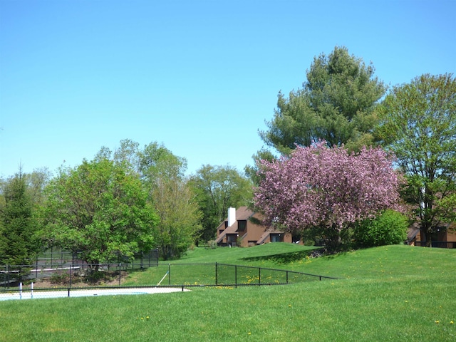 view of community featuring a yard and fence
